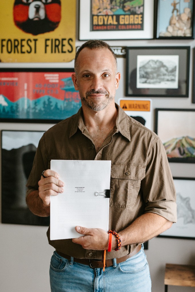 Chase Butala holding the Undefeated Man manuscript draft